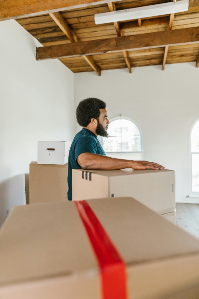 Customer standing with packed moving boxes in preparation for relocation