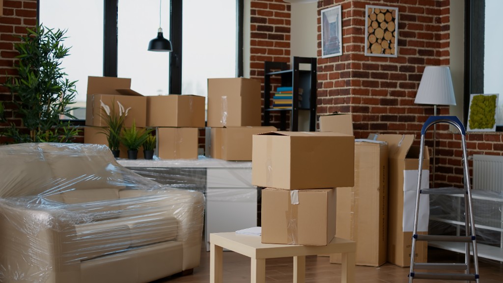 Packed room with protected furniture and stacked moving boxes
